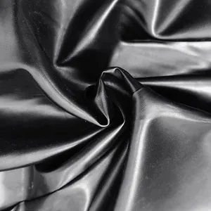 Macro detail showing the soft texture and glossy finish of black PU leather fabric