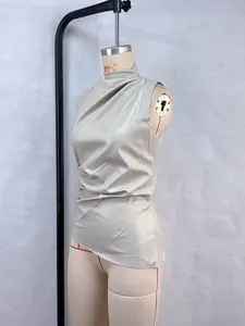 Sleeveless beige faux leather top with ruched high neck and asymmetrical hemline