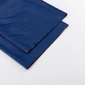 Close-up detail of the hem and smooth texture of blue PU leather straight-leg pants.