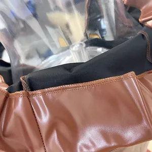 Detaillierte Nahaufnahme der feinen Nähte und des braunen PU-Leders bei einem Midikleid