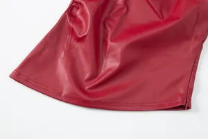 Primer plano del dobladillo de una prenda de cuero PU rojo con costuras y textura suave