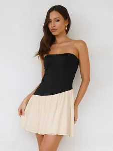 Detailopname van een elegante zwart-crème strapless geplooide mini-jurk op een model