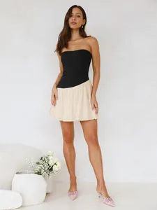 Gedetailleerde weergave van een chique tweekleurige strapless jurk in zwart en beige