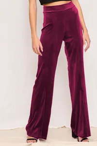 Detail view showing the texture and cut of high-waisted magenta velvet wide-leg pants