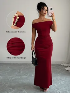 Detailed view of elegant burgundy off-the-shoulder maxi dress with ruched design and metal accents.