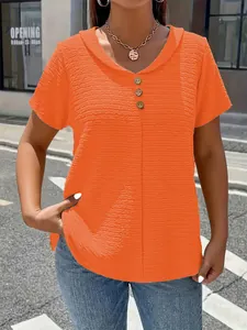 Detail showing orange V-neck short sleeve t-shirt with crinkle fabric and button trim