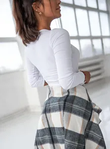 Close-up of white ribbed knit long sleeve slim fit top showing back and side detail
