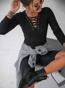 Detail shot of the crisscross lace-up V-neckline on a black ribbed knit long sleeve top