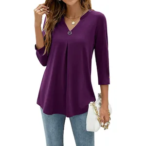 Close-up of purple V-neck 3/4 sleeve pleated blouse with metal button detail.