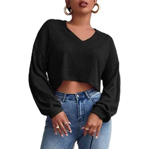Pull court en maille noire pour femme avec col en V et texture côtelée élégante