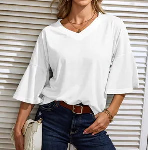 Elegant white V-neck blouse detail showing flowy bell sleeves and soft cotton texture