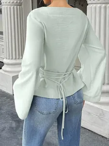 Elegant mint green long sleeve blouse with bell sleeves and tie waist detail back view.