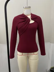 Vue détaillée d'un haut bordeaux à manches longues avec drapé asymétrique et boucle dorée
