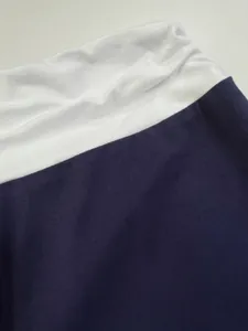 Κοντινό πλάνο της λευκής ελαστικής ζώνης στο ύφασμα του μπλε παντελονιού γιόγκα