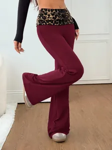 Vue détaillée d'un pantalon de yoga évasé bordeaux avec taille léopard. (81 chars)