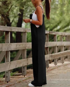 Full side profile of a woman wearing a casual black wide-leg jumpsuit on a wooden bridge