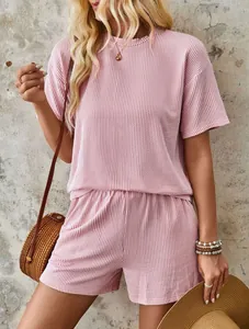 Close-up of pink pleated two-piece summer set with wavy texture and elastic waist shorts.