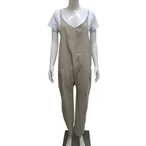 Front view detail of a beige oversized bib jumpsuit with patch pockets on mannequin