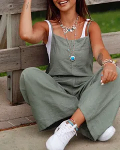 Vue lifestyle d'une femme portant une combinaison large vert sauge et un débardeur.