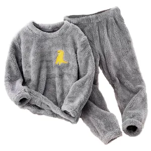 Detail view of cozy grey flannel kids' pajamas featuring a yellow cartoon dinosaur