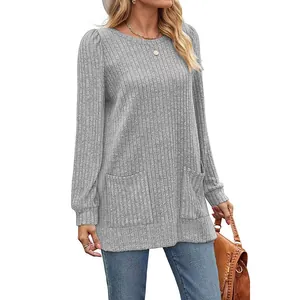 Una vista dettagliata della tunica in maglia grigia con tasche frontali e texture