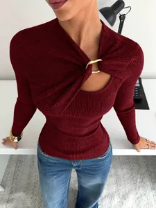 Détail d'un t-shirt bordeaux à manches longues avec décolleté asymétrique et boucle dorée.
