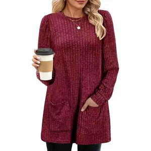 Dettaglio di una tunica in maglia a coste bordeaux da donna con pratiche tasche anteriori.