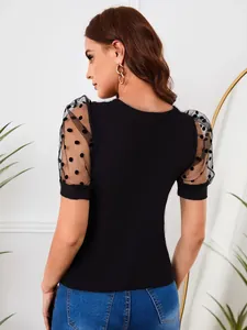 Λεπτομερής προβολή μαύρου t-shirt με διαφανή μανίκια με πουά σχέδιο και όγκο