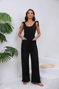 Vue détaillée d'une combinaison pantalon noire à jambes larges avec nœuds aux épaules