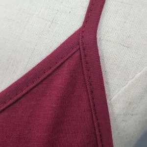Detailed view of the high-quality stitching on a wine red camisole dress neckline