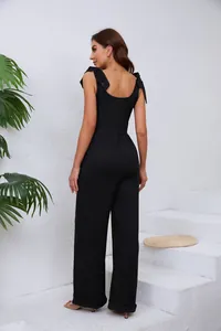 Vue arrière d'une combinaison noire élégante à jambes larges avec nœuds aux épaules