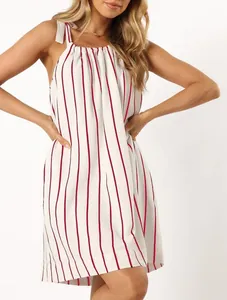 Detail of summer white striped dress with tie-shoulder bow straps and loose fit.