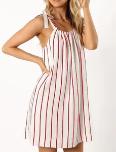Detailed close-up of white and red striped sleeveless summer dress with bow-tie shoulder straps