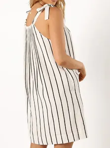Detailed side view of a white and black striped summer dress with bow-tie straps