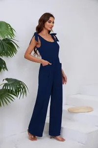 Détail latéral d'une combinaison bleu marine à col en U avec jambes larges et nœuds.