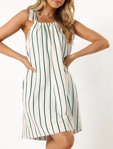 Detail view of summer white dress with vertical green stripes and tie-shoulder straps.