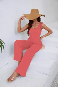 Détail d'une femme portant une combinaison corail à jambes larges sur escalier