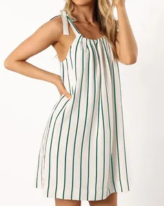 Detail view of a white summer dress with green vertical stripes and bow-tie straps.