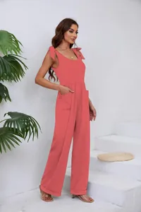 Vue latérale d'une combinaison rose à jambes larges avec nœuds et poches latérales.