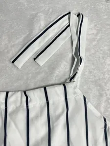 Close-up of white and black vertical striped dress showing the shoulder strap detail