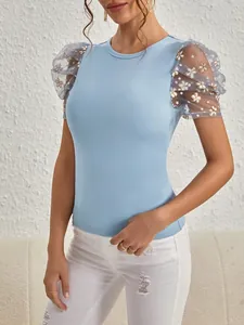 Detail eines hellblauen T-Shirts mit floralen Puffärmeln aus Netzstoff und Rundhals.