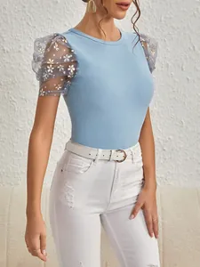 Detail eines blauen Slim-Fit-T-Shirts mit eleganten Blumen-Netz-Puffärmeln und Rundhals.