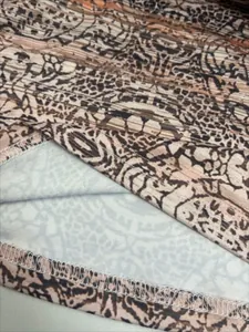 Close-up of leopard geometric print fabric with detailed hem stitching on a slim polo top.
