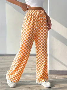 Close-up of vibrant orange and white checkerboard pattern high-waist wide-leg trousers