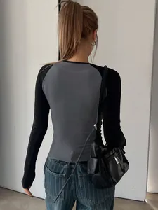 Back view of a grey and black long-sleeved slim fit cropped raglan t-shirt