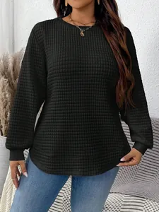 Close-up of black plus-size sweatshirt featuring a textured grid pattern and curved hem