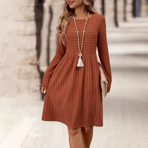 Vista de cerca de un vestido midi de punto acanalado color óxido con falda plisada retro
