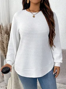 Close-up of premium white quilted fabric texture on plus size casual long sleeve top with curved hem