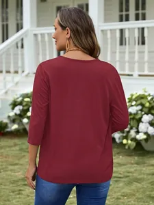 Back view of a casual burgundy women's long-sleeve knit top in an outdoor garden setting