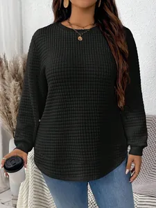 Detail view of plus-size black quilted sweatshirt with curved hem and round neck